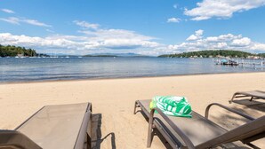 Une plage avec des chaises longues et une serviette verte posée sur l’une d’elles.