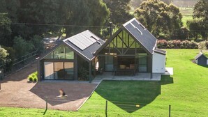 Een modern huis met een schuin dak, grote ramen en een verzorgd gazon.