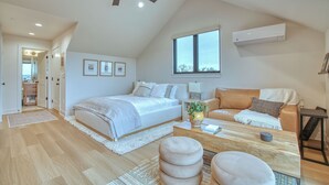 A spacious bedroom with a large bed, a sofa, a coffee table, and a ceiling fan. - Single Tree Haven + Optional Rental Car Delivery (Superior)