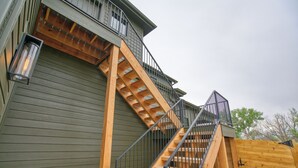 A wooden staircase leading to a balcony with a metal railing. - Single Tree Haven + Optional Rental Car Delivery (Superior)
