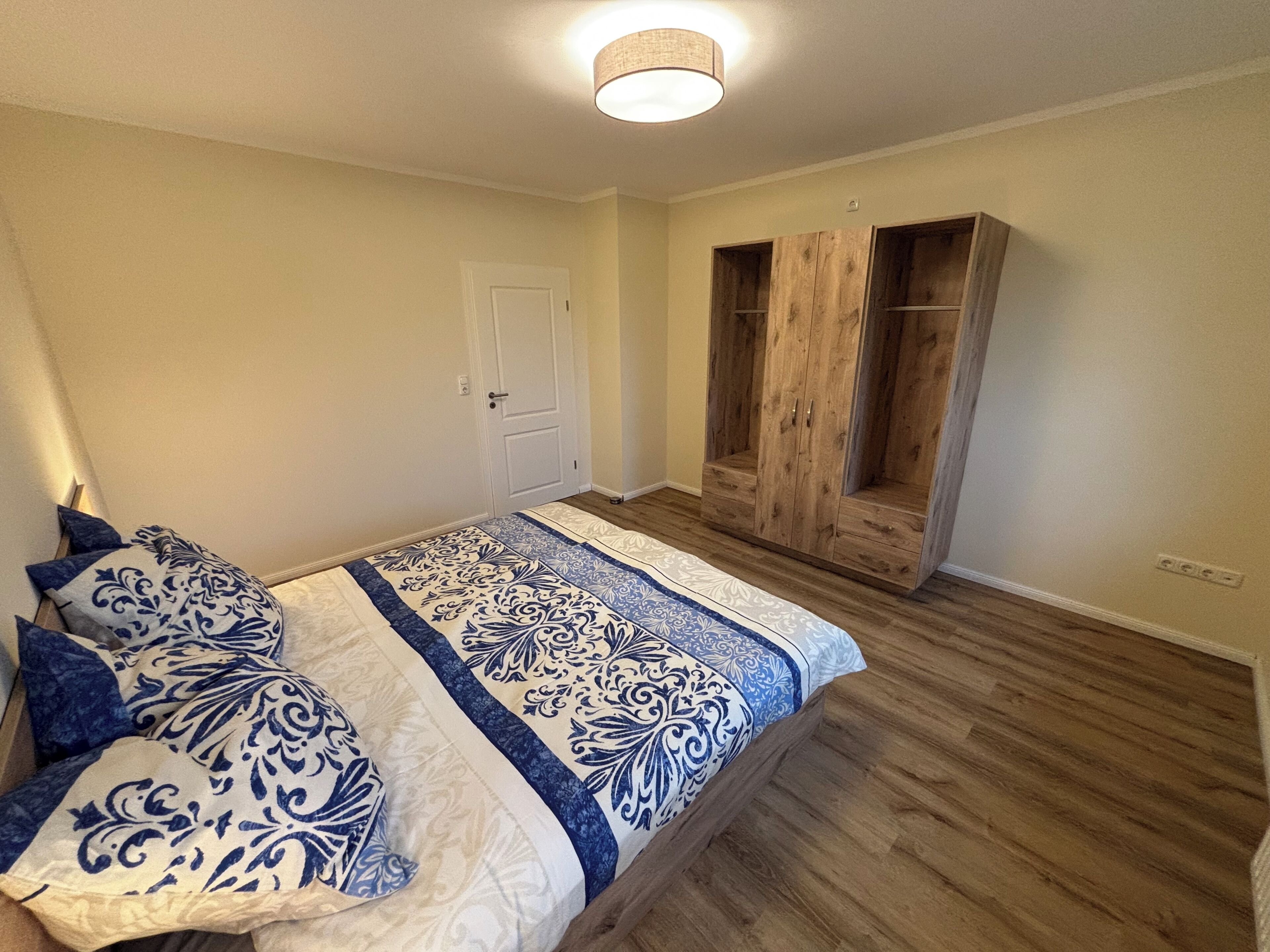 Une chambre à coucher avec un lit, une armoire et une porte.