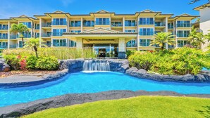 A hotel with a swimming pool, a waterfall, and lush greenery. - Fall Getaway at Oceanfront Waipouli Beach Resort (Kapaʻa)
