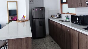A compact kitchen with a refrigerator, microwave, and sink. - Central and spacious apartment in Rionegro (Rionegro)