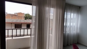 A balcony with a view of buildings and a red chair. - Central and spacious apartment in Rionegro (Rionegro)