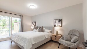 Ein Schlafzimmer mit Bett, Nachttischen, einem Sessel und Bildern an den Wänden.