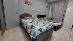 A bedroom with a bed, bedside tables, a desk, and a chair. - ARDENN HOTEL (Reims)