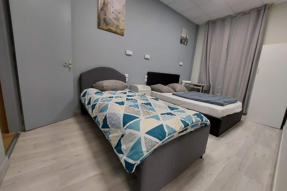 Un dormitorio con cama, mesitas de noche, escritorio y una silla.