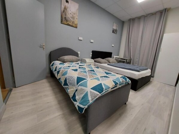 A bedroom with a bed, bedside tables, a desk, and a chair.