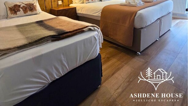 A hotel room with two beds, wooden paneling on the wall, and a large window with a view. - The Distinguished Squirrel - Room 4 - New Forest (Dibden Purlieu)