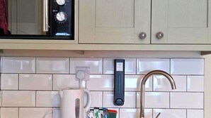 A kitchen with a microwave, a coffee maker, a faucet, and a power outlet. - Duke of the Pond - Room 1 - New Forest (Dibden Purlieu)