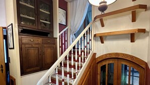 A staircase with white balusters and a wooden handrail, leading to a landing with a wooden door marked "N.D. 2006". - Villa with pool in a quiet hamlet among olive groves 8 km from the sea. (Chiusanico)