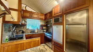 A kitchen with wooden cabinets, a stainless steel refrigerator, a microwave, and a gas stove. - Villa with pool in a quiet hamlet among olive groves 8 km from the sea. (Chiusanico)