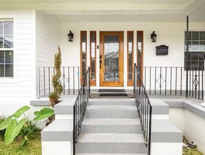 A front porch with a wooden door, a black mailbox, and a small plant. - 3-bedroom house Near everything in New Orleans (New Orleans)