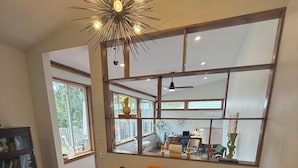 A dining area with a glass table, orange chairs, and a striped tablecloth. - A2 Oasis; Lovely Neighborhood; Walk to Stadium and Crisler Arena! (Ann Arbor)