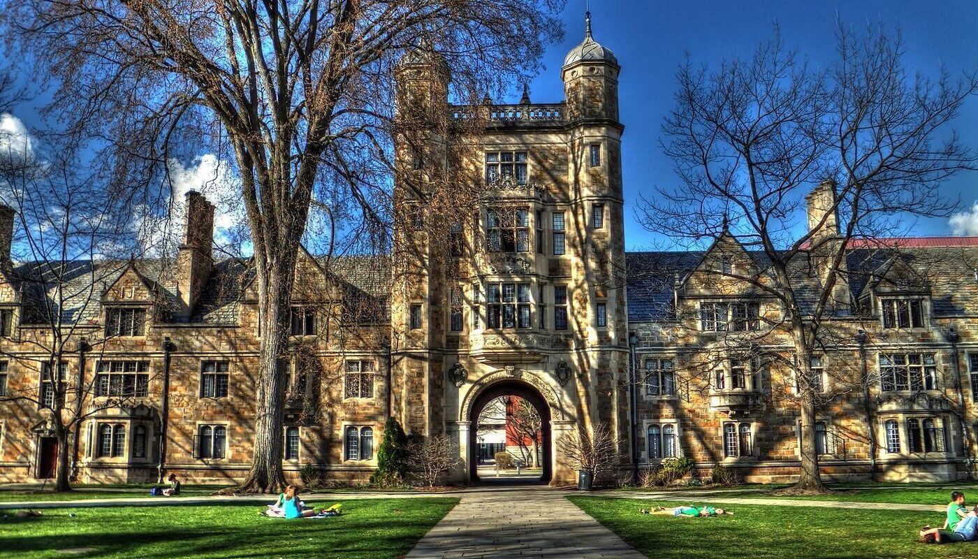 A historic building with a central tower, arched entrance, and symmetrical windows.
