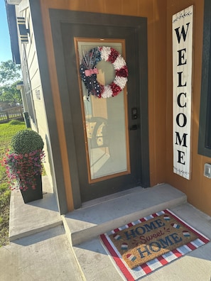 A front door with a wreath, a welcome sign, and a doormat. - Stylish 2Bdrm in perfect location-close to A&M, Midtown Park, & Blinn (Bryan)