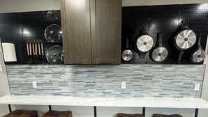 A kitchen with a white countertop, black stools, and a backsplash with gray tiles. - Stylish 2Bdrm in perfect location-close to Kyle Field & Midtown Park (Bryan)