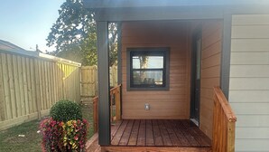 A wooden deck leading to a small covered porch with a window. - Stylish 2Bdrm in perfect location-close to Kyle Field & Midtown Park (Bryan)