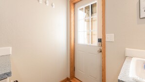 Ein Teil des Raumes mit einer weißen Tür, einem Holzrahmen und einem Fenster.