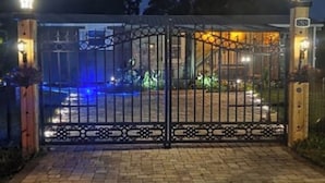 A gated entrance with a brick pathway leading to a building.