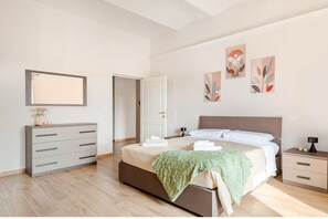Ein modernes Schlafzimmer mit Bett, Kommode und Nachttisch.