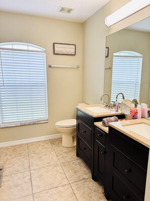 A bathroom with a toilet, a sink with a mirror, and a towel rack.
