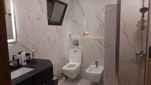 Een haardroger, handdoeken, zeep, toiletpapier