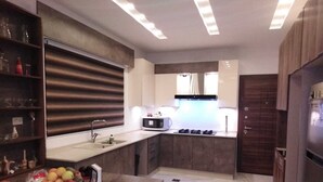Une cuisine moderne dotée d’un îlot central, d’appareils électroménagers intégrés et d’une grande fenêtre.
