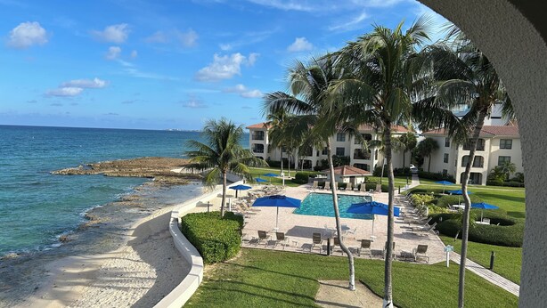 Ein Resort mit Pool, Palmen und Blick auf den Strand.