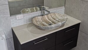 A bathroom with a marble sink, dark cabinets, and a mirror above the sink. - Shared house with other guests near shopping center and theme park (Upper Coomera)