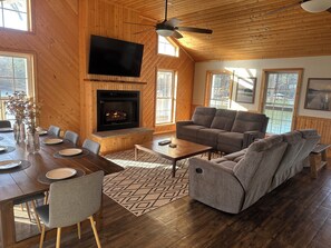 A cozy living room with a fireplace, a large TV, and comfortable seating.
