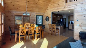 Ein Holzblockhaus-Interieur mit Essbereich, Küche und Wohnbereich.