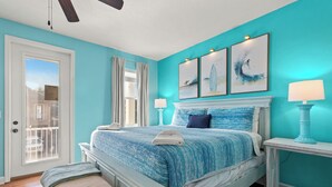 A bedroom with a bed, a bench, a nightstand, and a window with curtains. - Designer 5BR • Sleeps 14 • Dog OK + Pool-Hot Tub (Destin)