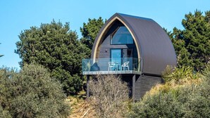 A modern, dome-shaped building with a balcony featuring outdoor seating.