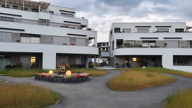 A modern residential complex with multiple balconies, a central garden area, and a paved walkway. - Modern, barrier-free apartment with garden access and terrace (Plauen)