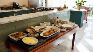 A buffet table with various dishes, a coffee machine, and a checkered placemat.