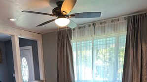 A living room with a sofa, a wooden coffee table, and a ceiling fan. - Soothing getaway farmhouse in Leeds near Hudson, Grace’s cafe, the creek, HITS. (Catskill)