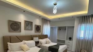 Un dormitorio moderno con dos camas, vestidor y baño.