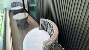 Un interior moderno con mobiliario de mimbre, un panel de vidrio y un diseño de paneles verticales.