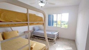 A dormitory room with bunk beds, a small desk, and a window with blinds. - Vacation, Apartment at the Beach Club Casa Blanca, Same, Ecuador (Same)