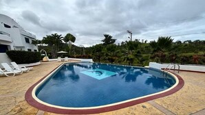 A swimming pool with a red border, surrounded by lounge chairs and palm trees. - Vacation, Apartment at the Beach Club Casa Blanca, Same, Ecuador (Same)