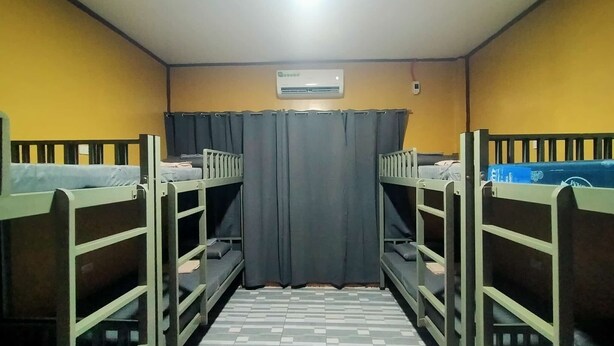 A dormitory room with bunk beds, a tiled floor, and a curtain. - Yelcalibre Room Rentals (San Juan)