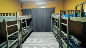 A dormitory room with bunk beds, a tiled floor, an air conditioning unit, and a curtain. - Yelcalibre Room Rentals (San Juan)