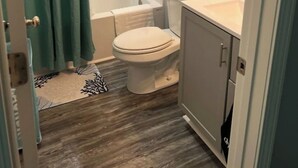 A compact bathroom with a shower, toilet, and sink. - BB On The Bayou  (Gautier)