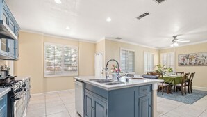 A spacious kitchen with a central island, built-in appliances, and a dining area with a table and chairs.