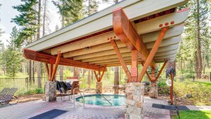 A covered outdoor area with a pool, stone pillars, and a wooden deck. - Northstar Ski-in/out Condo w/ Resort Amenities! (Truckee)