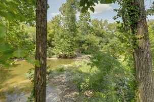 A natural landscape with a river, dense foliage, and trees.