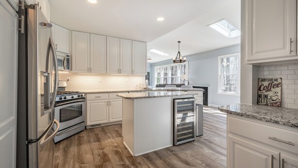 A modern kitchen with white cabinets, stainless steel appliances, and a central island. - Secluded Haven, Minutes from UNC Chapel Hill and Carrboro (Chapel Hill)