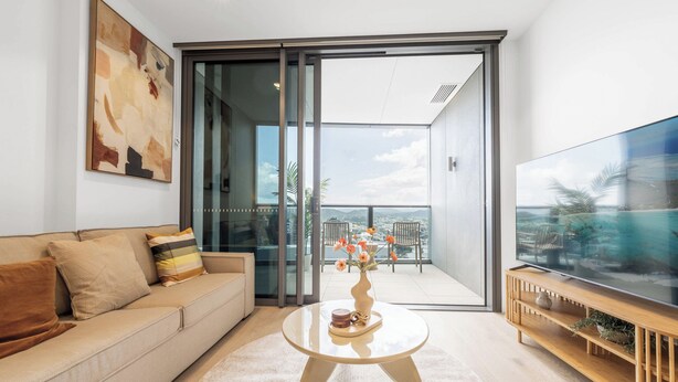 A modern living room with a sofa, coffee table, and TV.