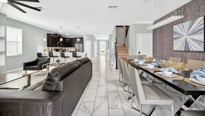 A modern kitchen with dark cabinets, a central island, and pendant lighting. - Super Mario & Frozen Castle Ultimate Stay with Free Access to Resort by Disney (Kissimmee)
